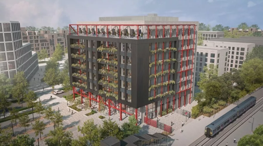 CGI of The Interchange office at Brabazon with black facade and red structural accents, featuring balconies adorned with plants. Surrounded by trees and located next to a railway line