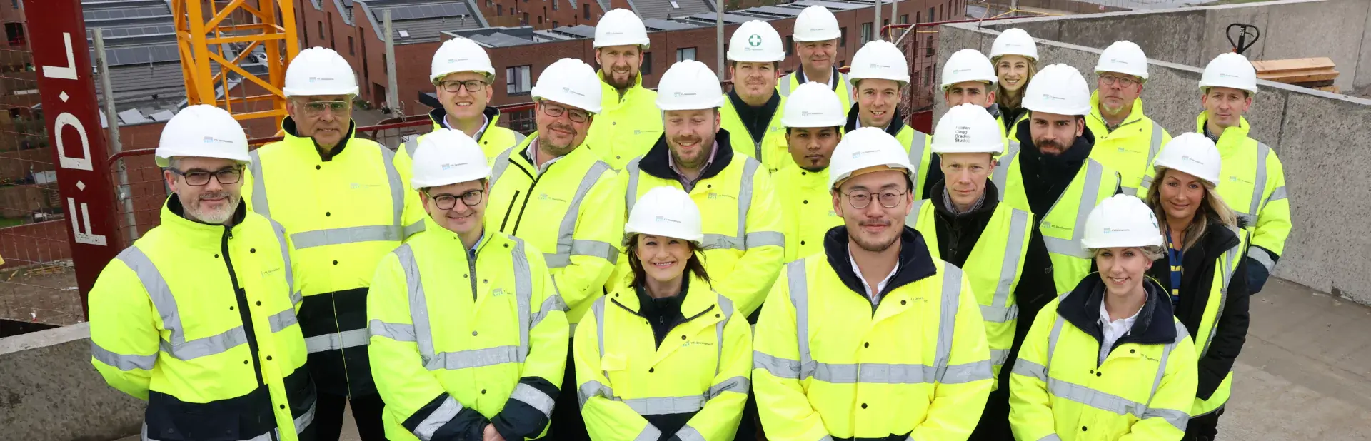 A group image of YTL Developments employees wearing visibility jackets and hard hats