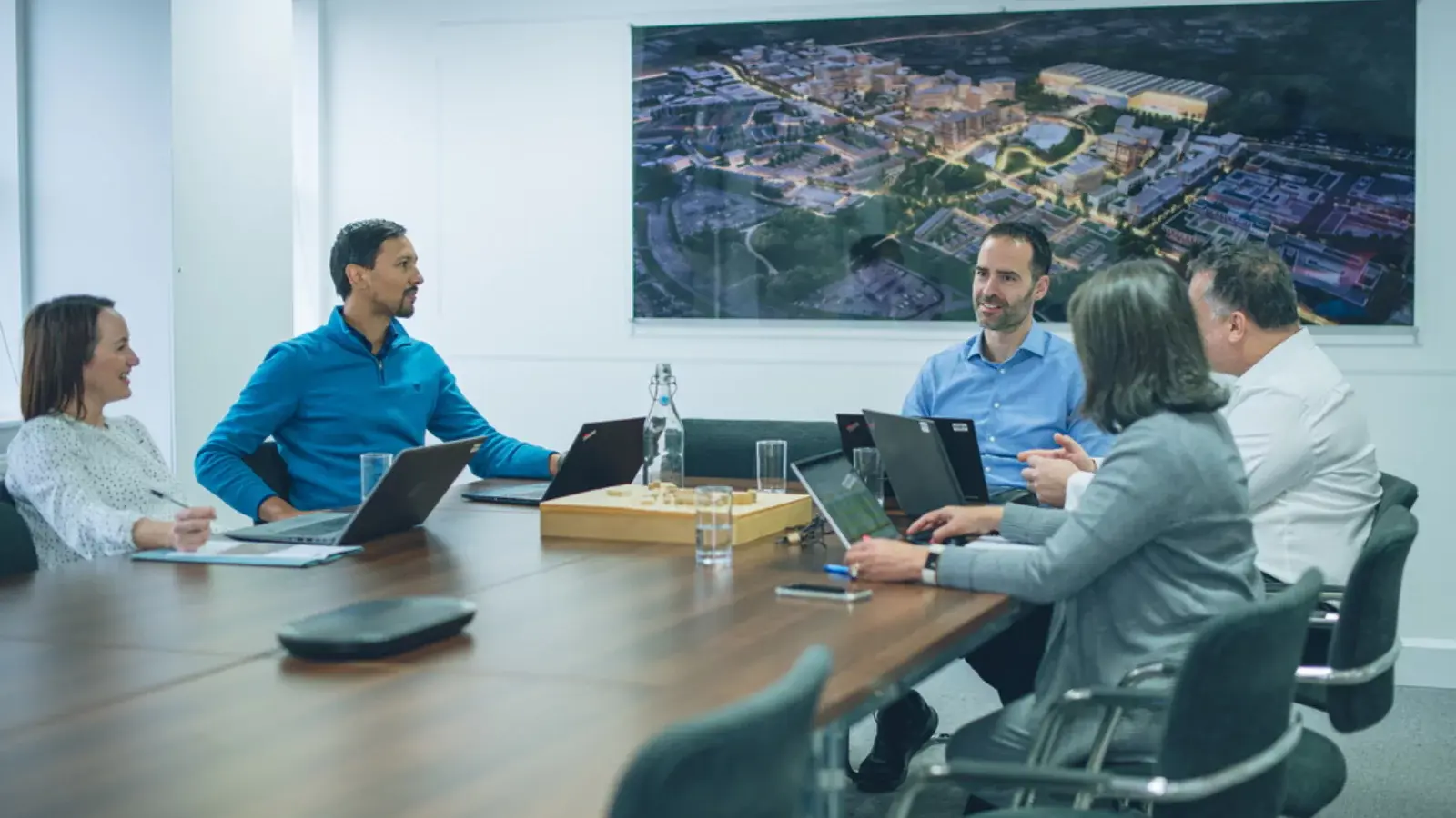 Four YTL Developments employees talking in an office meeting room